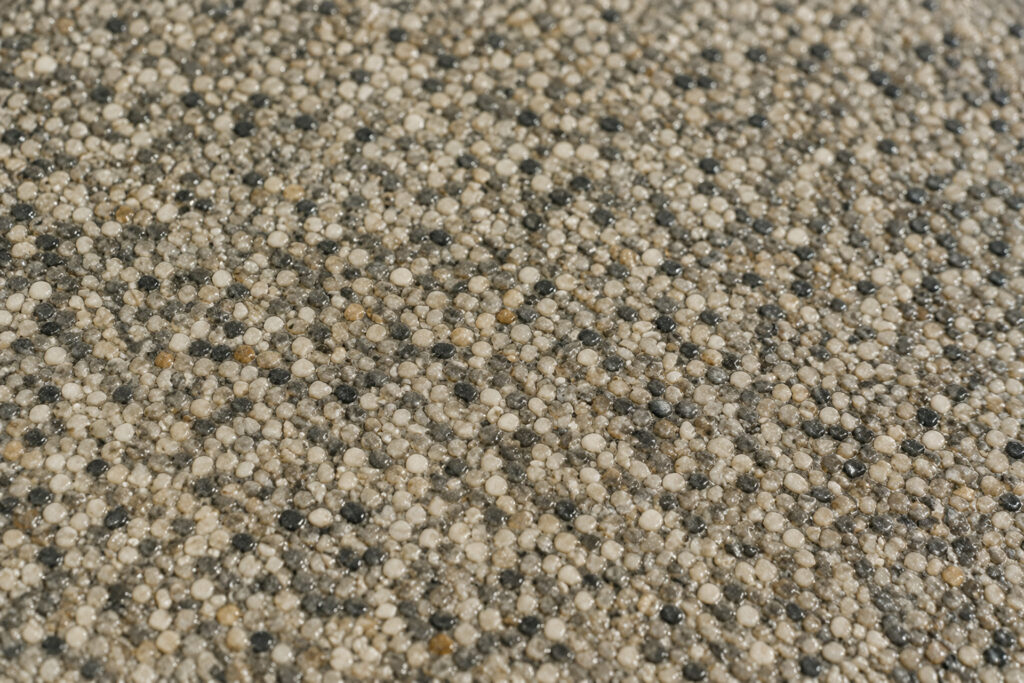Detailaufnahme eines hochwertigen Steinteppichs mit natürlicher Natursteinoptik in Beige- und Grautönen